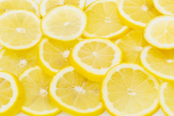 Některé citrony bohaté na vitamíny krájené a umístěné bok po boku jako pozadí. Vodorovně - Fotografie, Obrázek