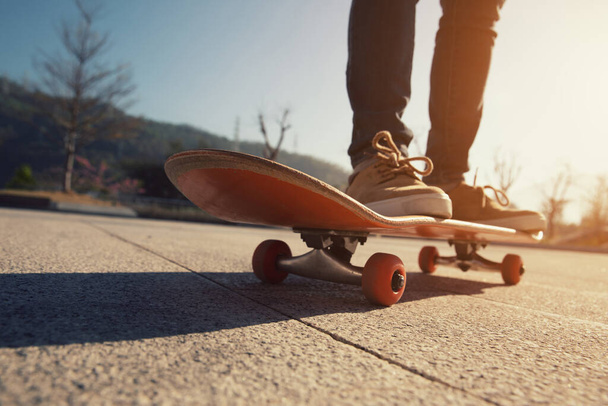 Skateboarder skateboarding outdoors on sunny morning - 写真・画像