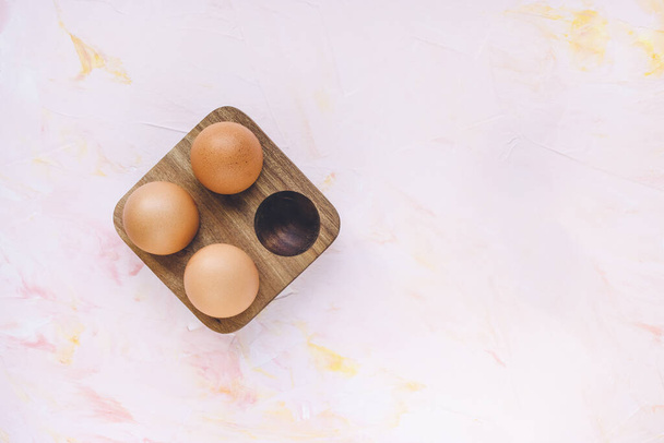 Three brown eggs in a wooden storage organizer box - Zdjęcie, obraz