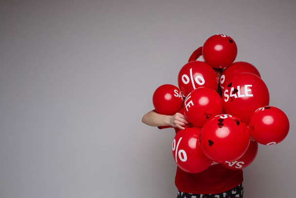 Mladá žena pózuje s mnoha červenými balónky - Fotografie, Obrázek
