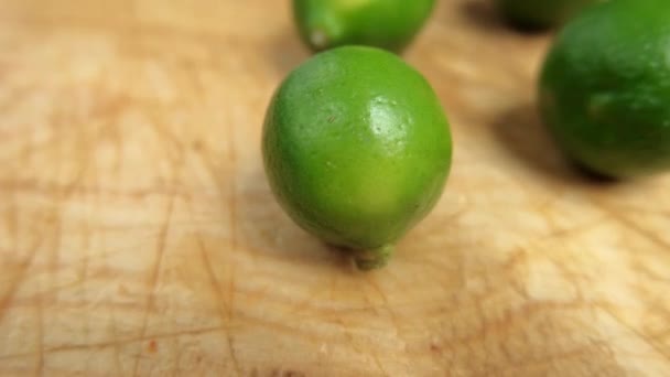 Limes fraîches isolées sur une table en bois rayé - Séquence, vidéo