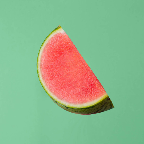 vers rauw watermeloen stuk geïsoleerd op groene achtergrond - Foto, afbeelding