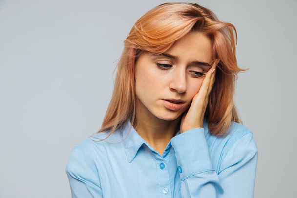 Displeased woman nearly falling asleep at work, hold her head with hand.Sleepy student spending time in university, feels lack of energy. Sleep deprivation, insomnia, apathy, weariness concept - Photo, Image