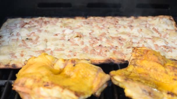 Cook eltávolítja a pizzát egy barbecue sütő konyhai fogóval - Felvétel, videó