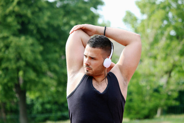 man stretching arm and listening to music - Photo, Image