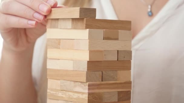 Closeup of businesswoman putting blocks and bricks of high tower. Concept of stability, development, success and business growth. Building and developing business - Footage, Video