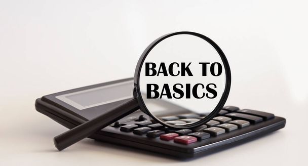 Focused on back to basics concept. Magnifier glass with text on calculator. Business - Photo, Image