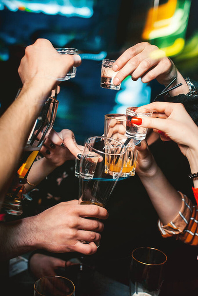 Close-up cheers clinking of friends with glasses in hands. Drink in party night. - Foto, Imagen