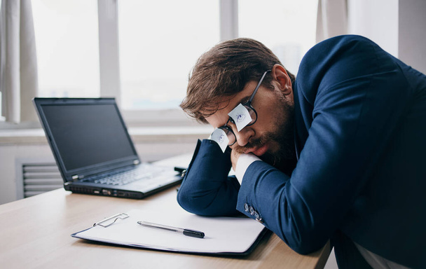 Business man sleeping at work wearing glasses with sheets of paper - Foto, Imagem