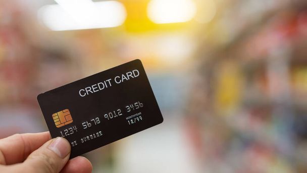Cartão de crédito preto na mão com fundo borrado - Foto, Imagem