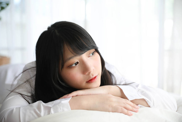 Portrét krásná asijská dívka spí na posteli v bílém pokoji  - Fotografie, Obrázek