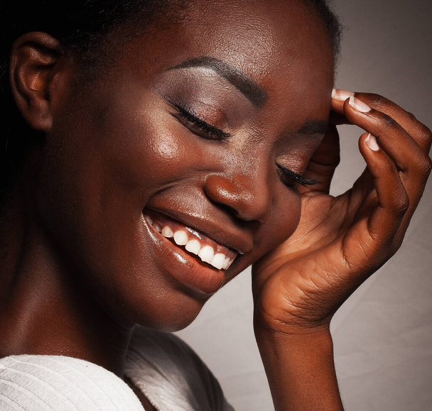 Lifestyle and people concept: Close up portrait of beautiful young african woman laughing, studio shot - Photo, Image