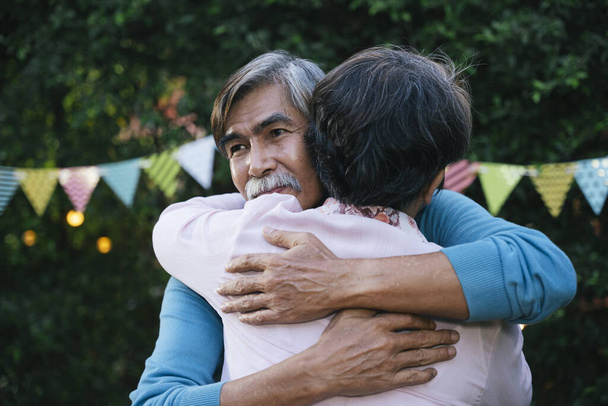 Romantiek aziatisch senior paar knuffelen en omarmen elkaar buiten. - Foto, afbeelding