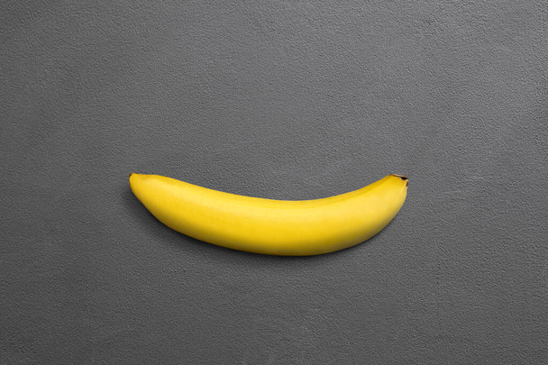 Одномісний банан на фоні темно-сірої бетонної текстури
. - Фото, зображення