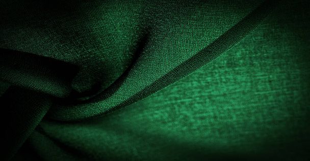 Dünne dunkelgrüne Chiffonseide, smaragdgrüner abstrakter Hintergrund. Nahaufnahme aus grünem Stoff. - es ist ein weiches transparentes Gewebe mit einer leichten Rauheit (matt, creme) aufgrund der Verwendung von gedrehtem Garn. Textur - Foto, Bild