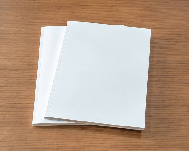 Libro maqueta con portada blanca en blanco página a4 maqueta en rústica para catálogo, revista, menú, folleto, cuaderno, plantilla de diseño de cartera sobre fondo de tabla de madera  - Foto, imagen