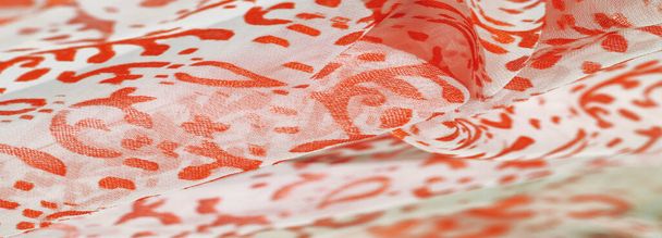 Tela de seda, tonos rojos rubí de delicados colores exquisitos sobre un fondo blanco, foto de un estampado Paisley. Textura, patrón, colección - Foto, imagen