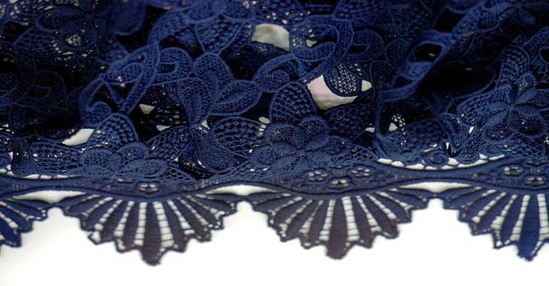 Koronkowy materiał w kolorze niebieskim. Czysta bawełniana koronka z kwiatowym wzorem ozdobiona haftem. Przejrzystość światła. Teksturowane. Kontekst. Wzór - Zdjęcie, obraz