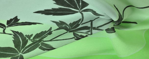 zelená hedvábná tkanina s květinovým vzorem. černý otisk, nádherná látka. Textura, pozadí - Fotografie, Obrázek