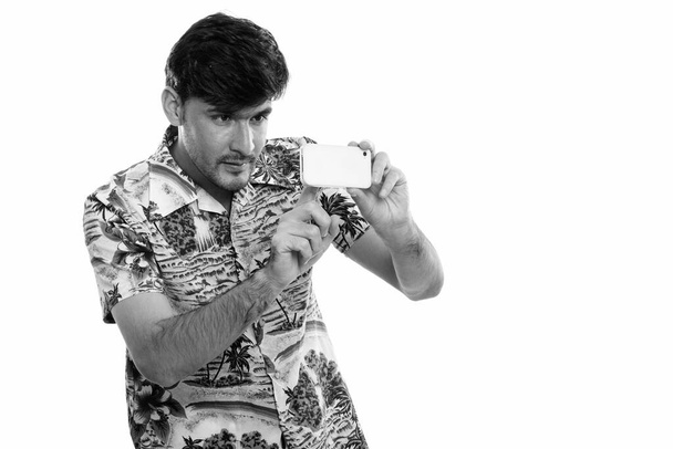 Huomaavainen nuori persialainen mies ottaa kuvan matkapuhelimella - Valokuva, kuva