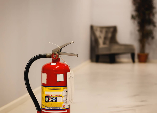 Красный огнетушитель готов к использованию в случае пожара в помещении. - Фото, изображение