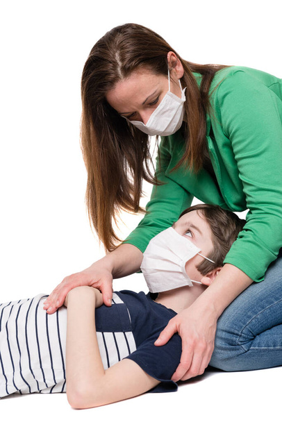 Woman with face mask taking care of sick little boy, isolated on white background - Photo, Image