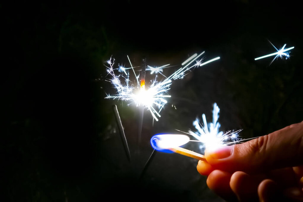 Πυροτέχνημα, βεγγαλικά και φώτα bokeh σε σκούρο μπλε φόντο - Φωτογραφία, εικόνα