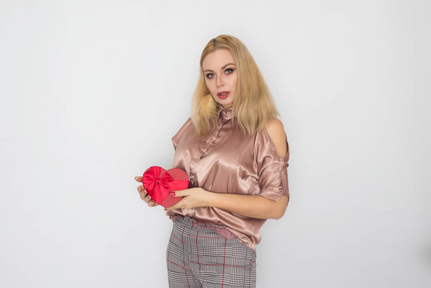 Valentines Day - dreaming woman in pink blouse holding red gift box heart - Fotó, kép