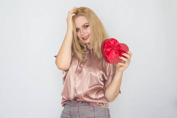 Valentines Day - dreaming woman in pink blouse holding red gift box heart - Фото, зображення