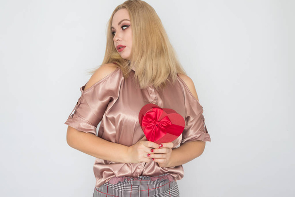Valentines Day - dreaming woman in pink blouse holding red gift box heart - Foto, Imagem