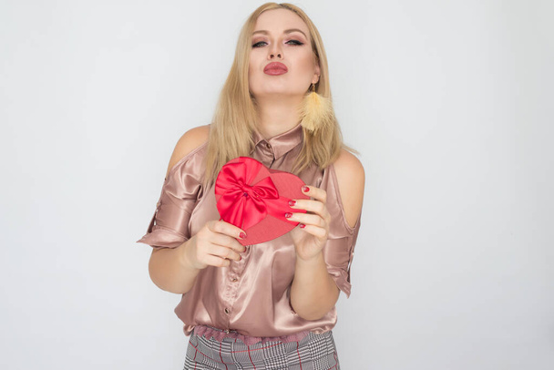 Valentines Day - dreaming woman in pink blouse holding red gift box heart - Фото, зображення