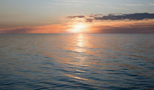 zasněný západ slunce s zapadajícím sluncem nad oceánem a odraz vody, romantická scenérie - Fotografie, Obrázek