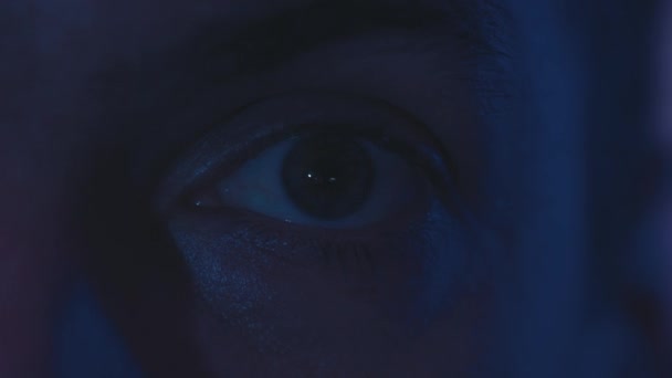 Detailní odraz v oku světla z obrazovky. Makrooči mladého muže, který se v noci dívá na film. Rychlý přenos zpráv. - Záběry, video