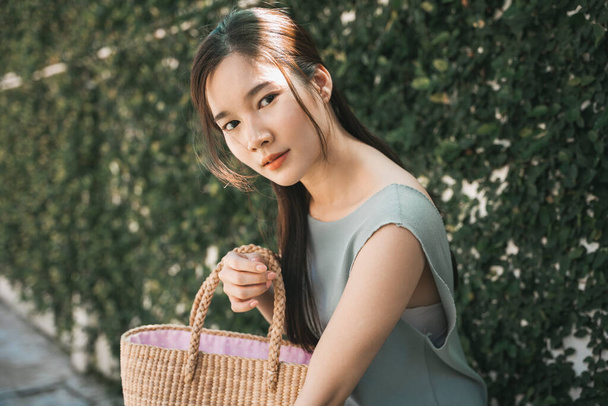 Junge asiatische Schönheit hält Einkaufstasche im Park. - Foto, Bild