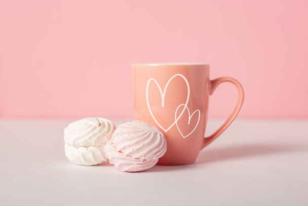 Mug with earring and sweets on a pink background. Valentine's Day concept. Banner. - 写真・画像