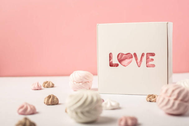 Caja de regalo con la inscripción Amor y dulces sobre fondo rosa. Concepto de regalo del día de San Valentín. Enfoque estrecho. Banner. - Foto, imagen