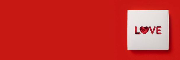 Dárkový box s textem Láska na červeném pozadí. Složení Valentýna. Banner. Byt ležel, horní pohled. - Fotografie, Obrázek