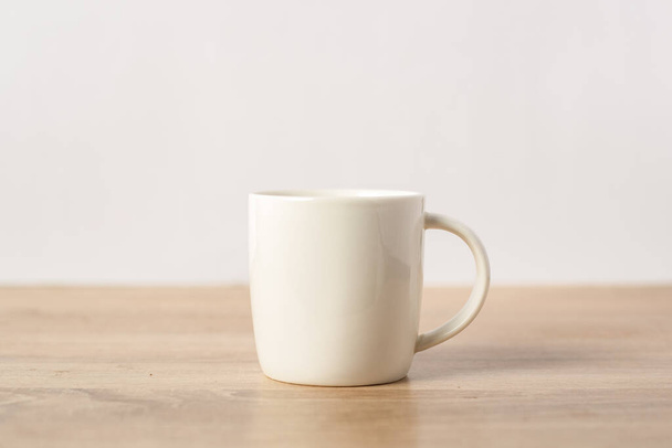 A mug with a hot drink on the table. Breakfast or coffee at night. - Photo, Image