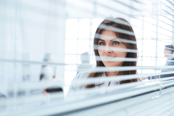 young business woman looking through office window - 写真・画像