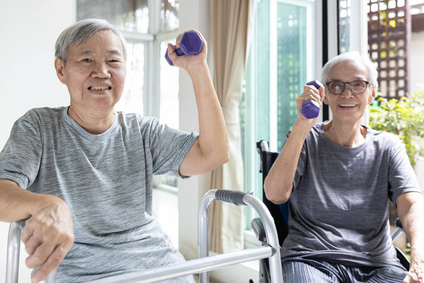 Vahva vanhempi nainen ja terve aasialainen isoäiti nauttivat liikunnasta nostamalla painoja, vanhat vanhukset, jotka työskentelevät käsipainoilla kotona, koulutus ja fysioterapia, elämäntapa, hyvä terveys - Valokuva, kuva