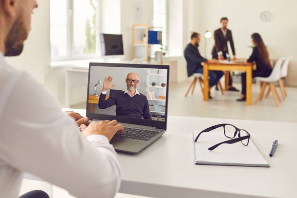Man having online video meeting with senior boss or company client or attending educational webinar - Fotó, kép
