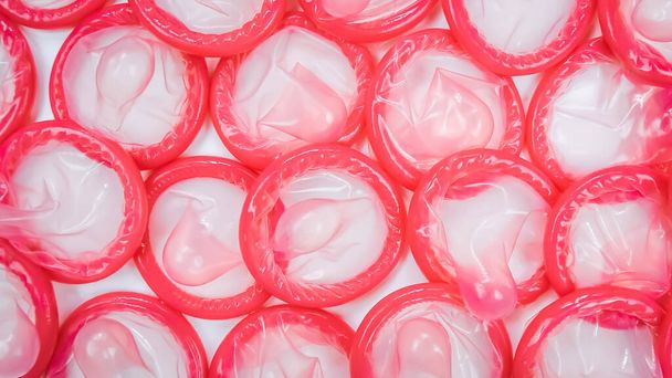 Detailní záběr růžových kondomů na bílém pozadí. Koncept bezpečného sexu. Snížení těhotenství a pohlavně přenosných nemocí. - Fotografie, Obrázek