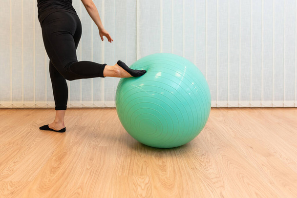girl pilates trainer does split fitball posture in fitness center - Photo, Image