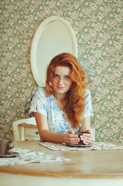自宅で晴れた朝にコーヒーを飲むそばかすのある若い赤毛の女性の肖像画。自然の美しさ。女の日だ。静物画. - 写真・画像