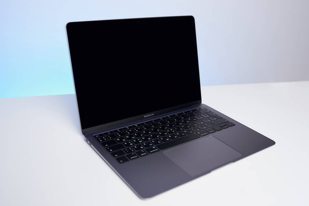Minsk, Belarus - December 04 2020: an opened brand new Space Gray MacBook Air 2019 on the white table. The laptop designed by Apple in California, assembled in China - Foto, imagen