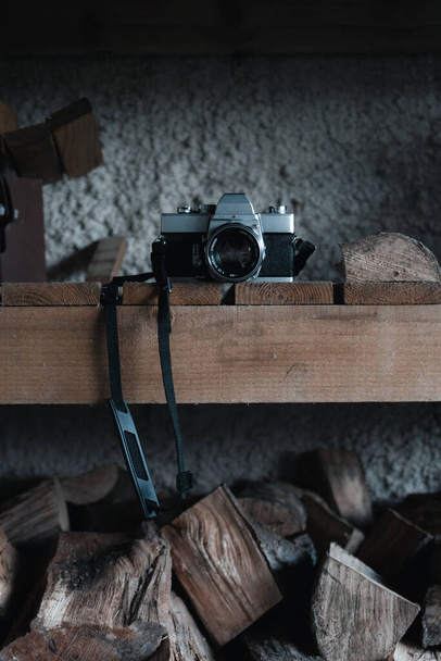 Filmkamera egy tűzifával teli fa polcon - Fotó, kép
