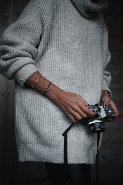 Unrecognizable woman handling a film camera wearing winter clothes - Photo, Image