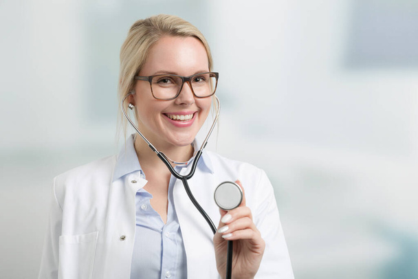Portrait of a smiling  female family doctor in doctor's overall with stethoscope - Photo, Image
