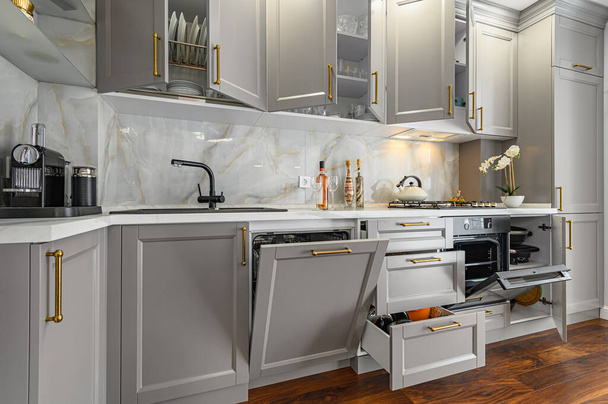 Lähikuva yksityiskohtia harmaa ja valkoinen moderni klassinen keittiö, kaikki ovet ovat auki - Valokuva, kuva