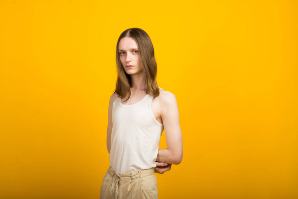 Androgynous beautiful young man. Model tests in yellow background - Фото, зображення